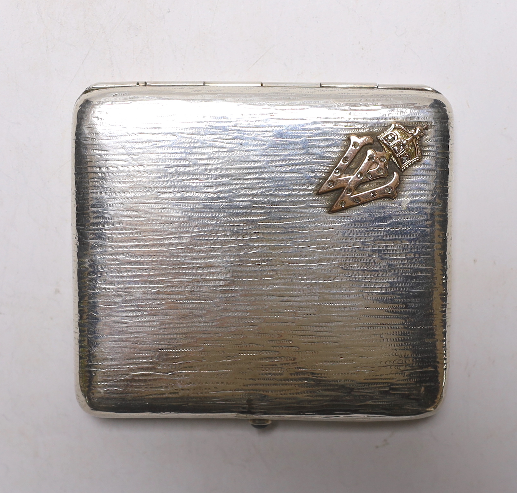 A German 800 standard white metal cigarette case by C.B. Friedlaender, with rose cut diamond set yellow metal Kaiser Wilhelm cipher and cabochon set button, 89mm, gross weight 112 grams.